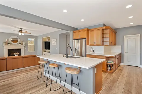 a kitchen with stainless steel appliances granite countertop a kitchen island a stove a table and chairs in it