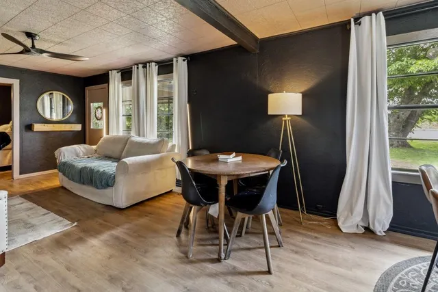 a living room with furniture a ceiling fan and a flat screen tv