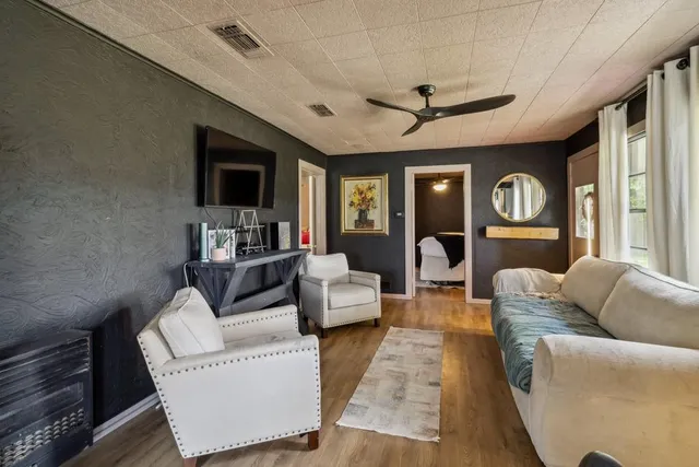 a living room with furniture kitchen view and a large window