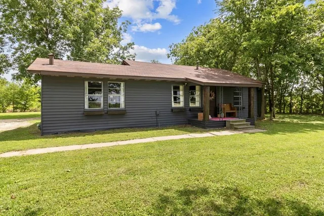 a view of a house with backyard and a tree