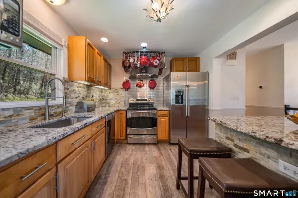 a kitchen with stainless steel appliances granite countertop a sink stove and refrigerator