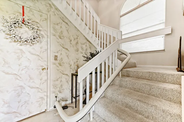 a view of staircase with wooden floor and next to a window