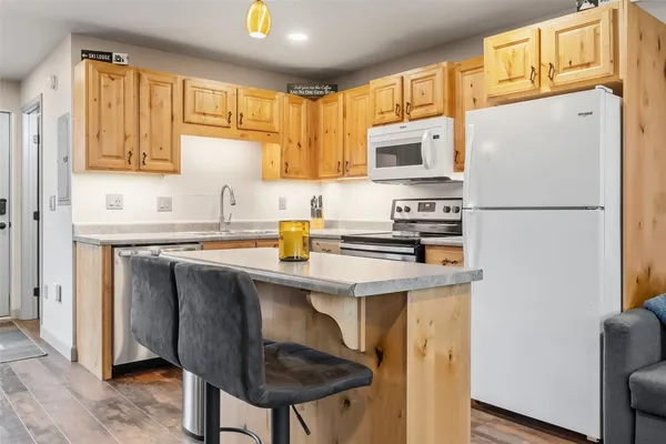 a kitchen with stainless steel appliances a refrigerator a sink a stove a microwave and cabinets