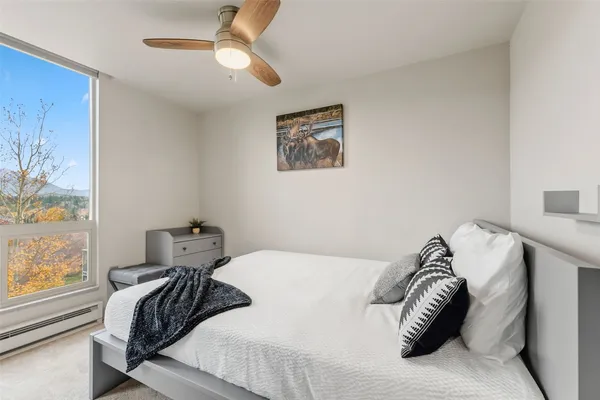a bedroom with a bed and a painting on the wall