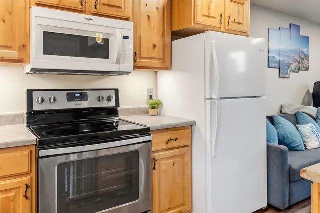 a white refrigerator freezer and a stove sitting inside of a kitchen