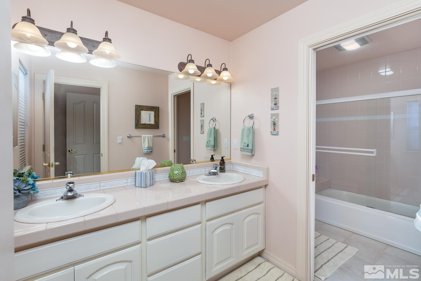 5275 Rivers Edge Drive Fallon, NV 89406 - Photo 17 of 36 a bathroom with a double vanity sink mirror and shower