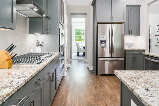 a kitchen with kitchen island granite countertop a sink stove and refrigerator