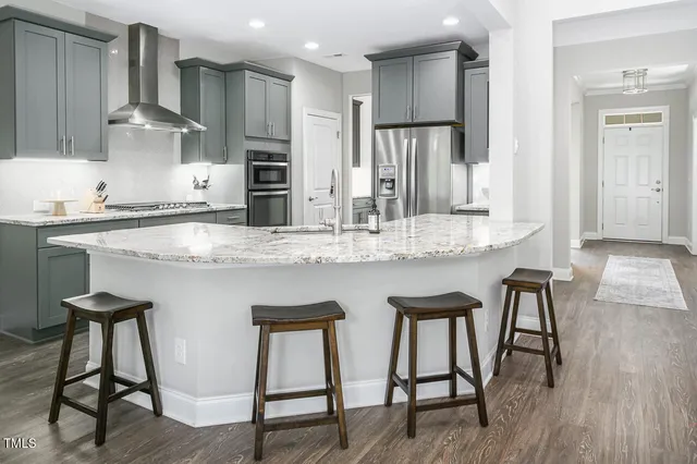 a kitchen with stainless steel appliances granite countertop table chairs sink and cabinets
