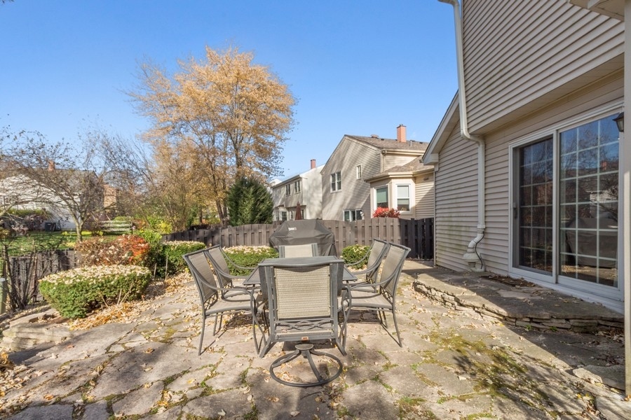 1164 Devonshire Road Buffalo Grove, IL 60089 - Photo 19 of 20 a patio with table and chairs and potted plants