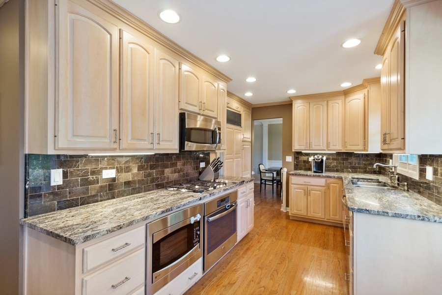 1164 Devonshire Road Buffalo Grove, IL 60089 - Photo 5 of 20 a kitchen with stainless steel appliances granite countertop a stove a sink and a microwave