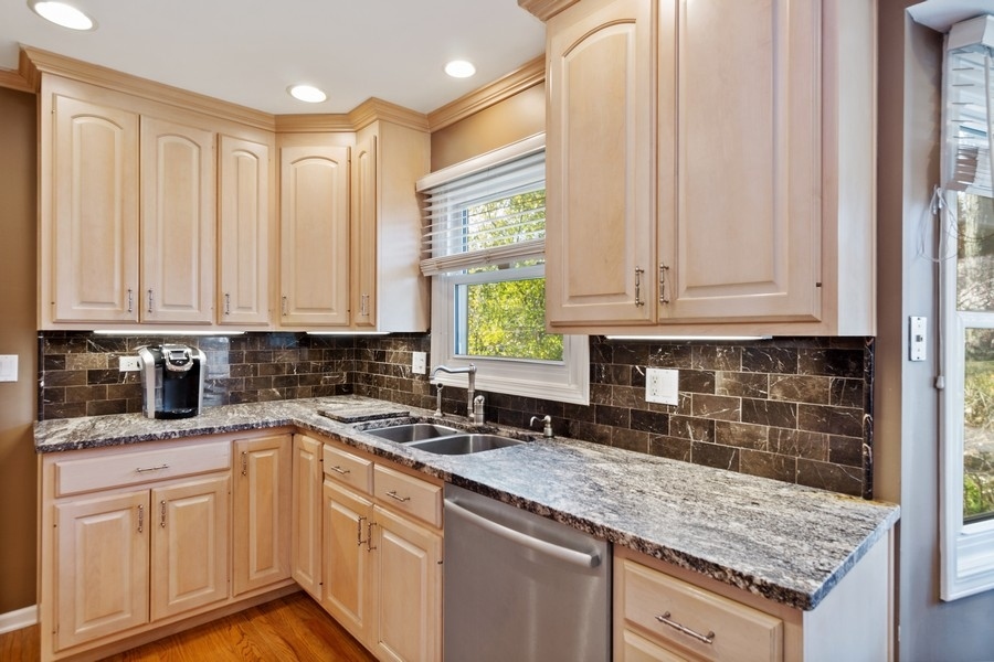 1164 Devonshire Road Buffalo Grove, IL 60089 - Photo 6 of 20 a kitchen with stainless steel appliances granite countertop a sink and cabinets