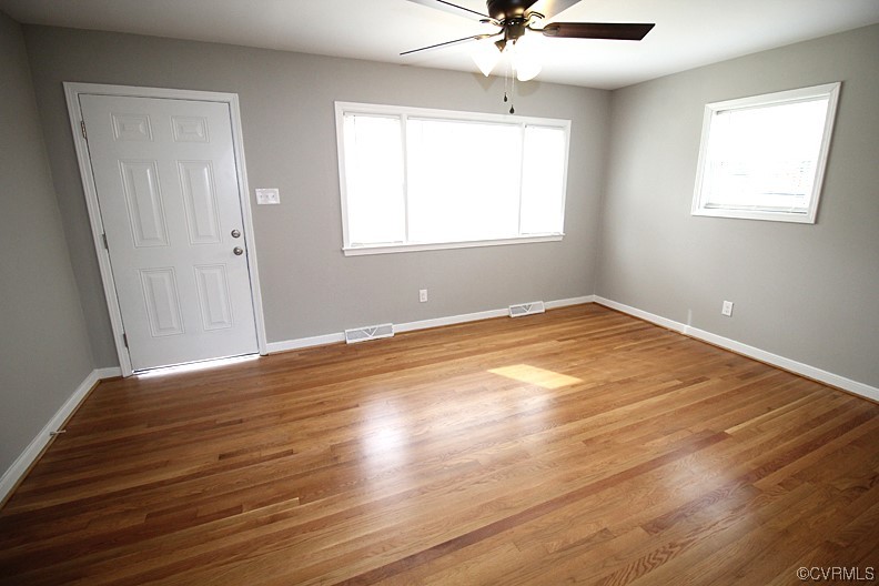 6440 Commander Road Richmond, VA 23224 - Photo 7 of 20 a view of an empty room with wooden floor and a window