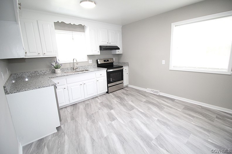 6440 Commander Road Richmond, VA 23224 - Photo 8 of 20 a kitchen with granite countertop white cabinets and white appliances