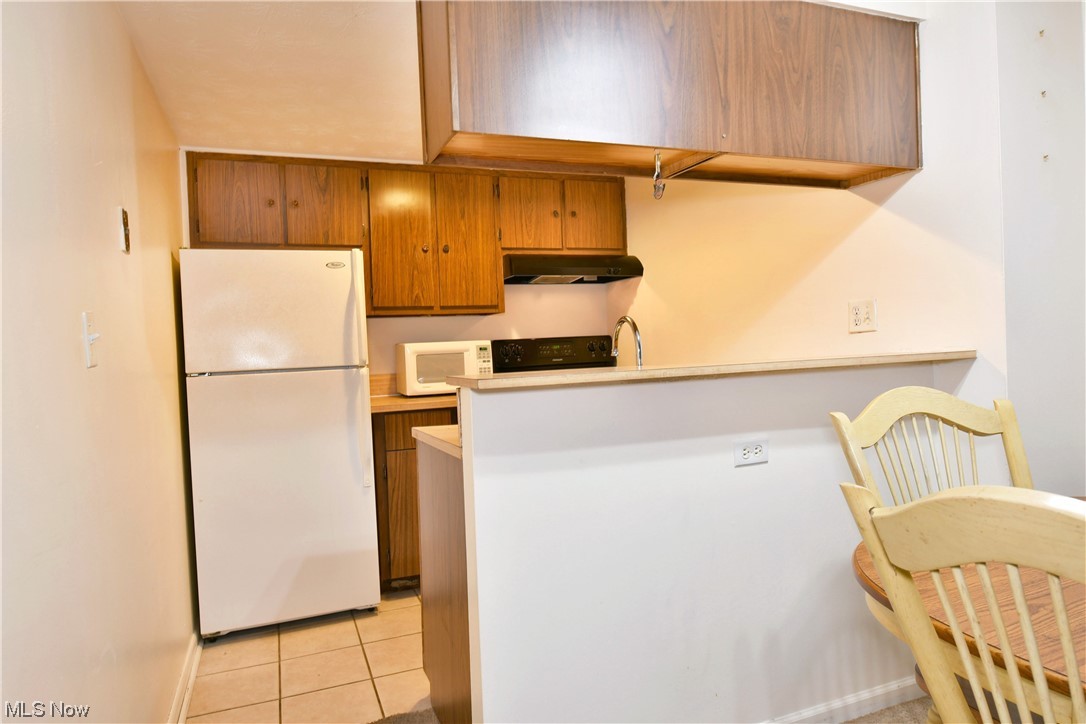 2980 North River Road Northeast, Unit E3 Warren, OH 44483 - Photo 7 of 27 Kitchen featuring light tile flooring and white appliances