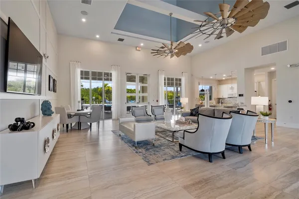 a living room with couches a fireplace and a dining table with wooden floor