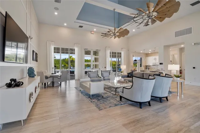 a living room with couches a fireplace and a dining table with wooden floor