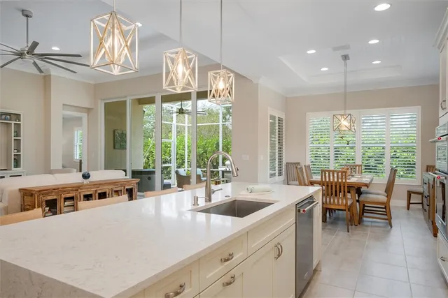 a large white kitchen with a large window and stainless steel appliances