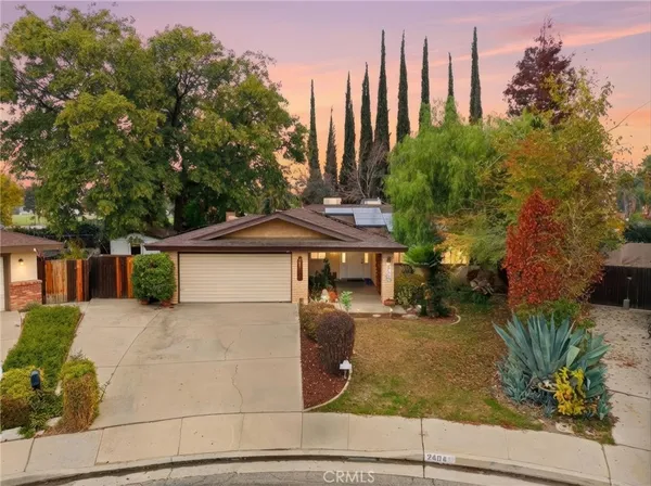 a view of a house with backyard and trees