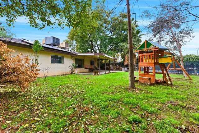 a view of a house with a yard patio and a slide