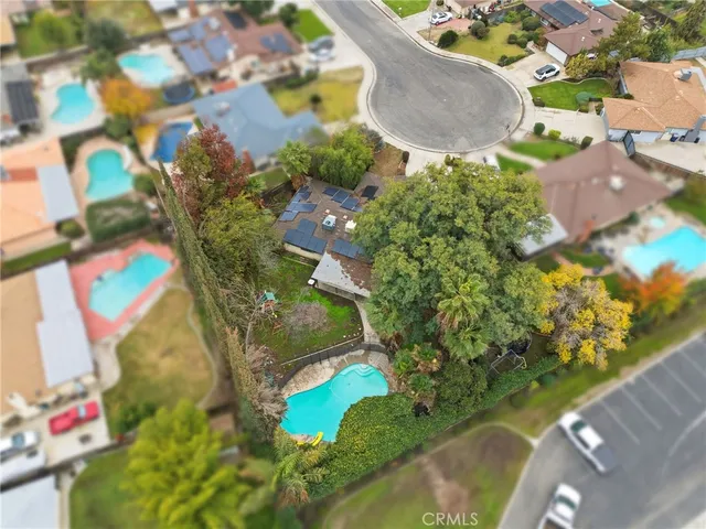 an aerial view of a house with a yard and tennis court