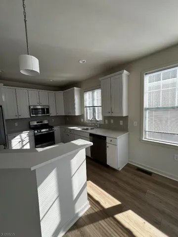 a kitchen with granite countertop a stove a sink and a refrigerator