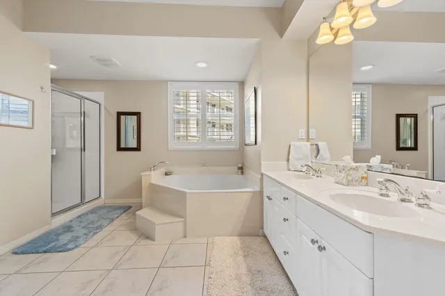 a spacious bathroom with a bathtub sink and mirror