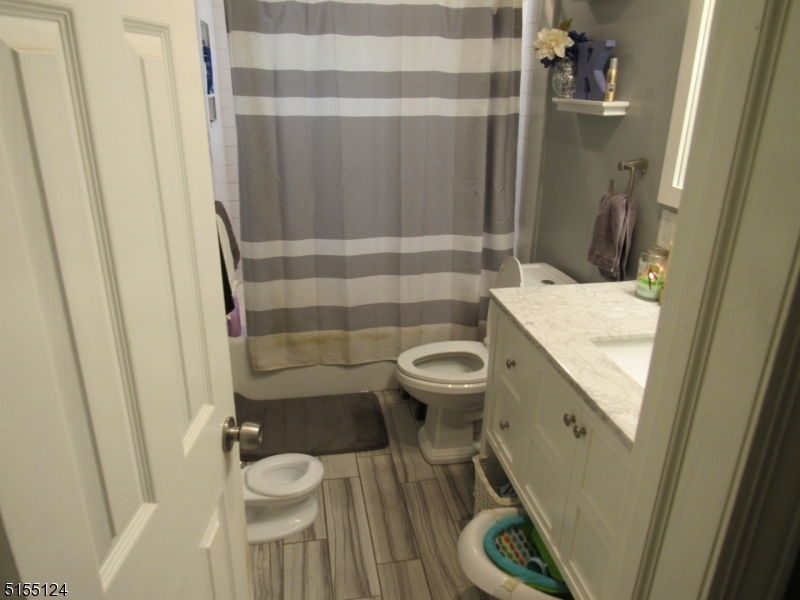 1033 Grove Street North Brunswick, NJ 08902 - Photo 5 of 14 a bathroom with a sink a toilet a shower and a mirror