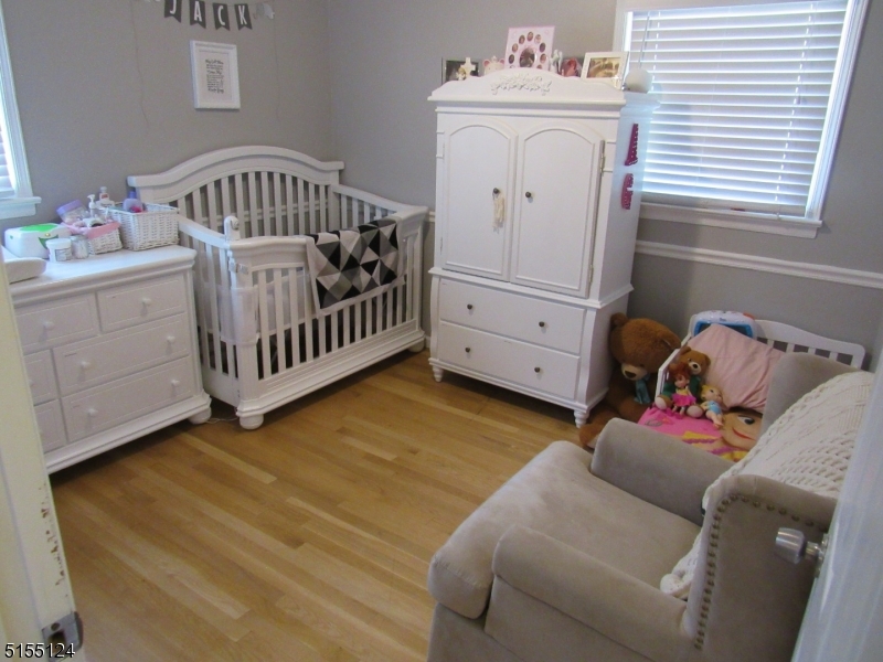 1033 Grove Street North Brunswick, NJ 08902 - Photo 6 of 14 a bedroom with a baby bed baby crib and a dresser