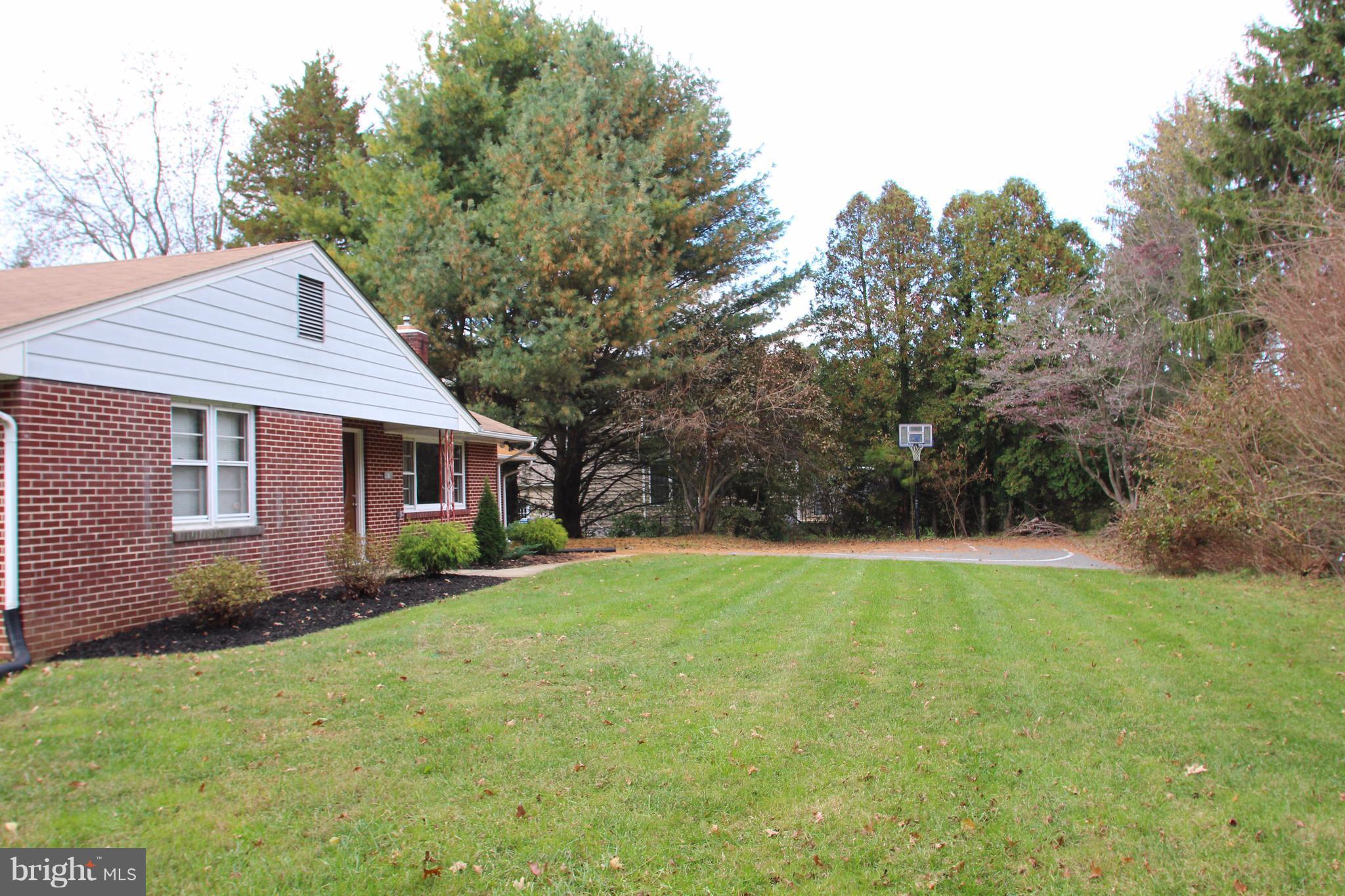 610 Mountain Road Fallston, MD 21047 - Photo 2 of 29 a backyard of a house with large trees and brick wall