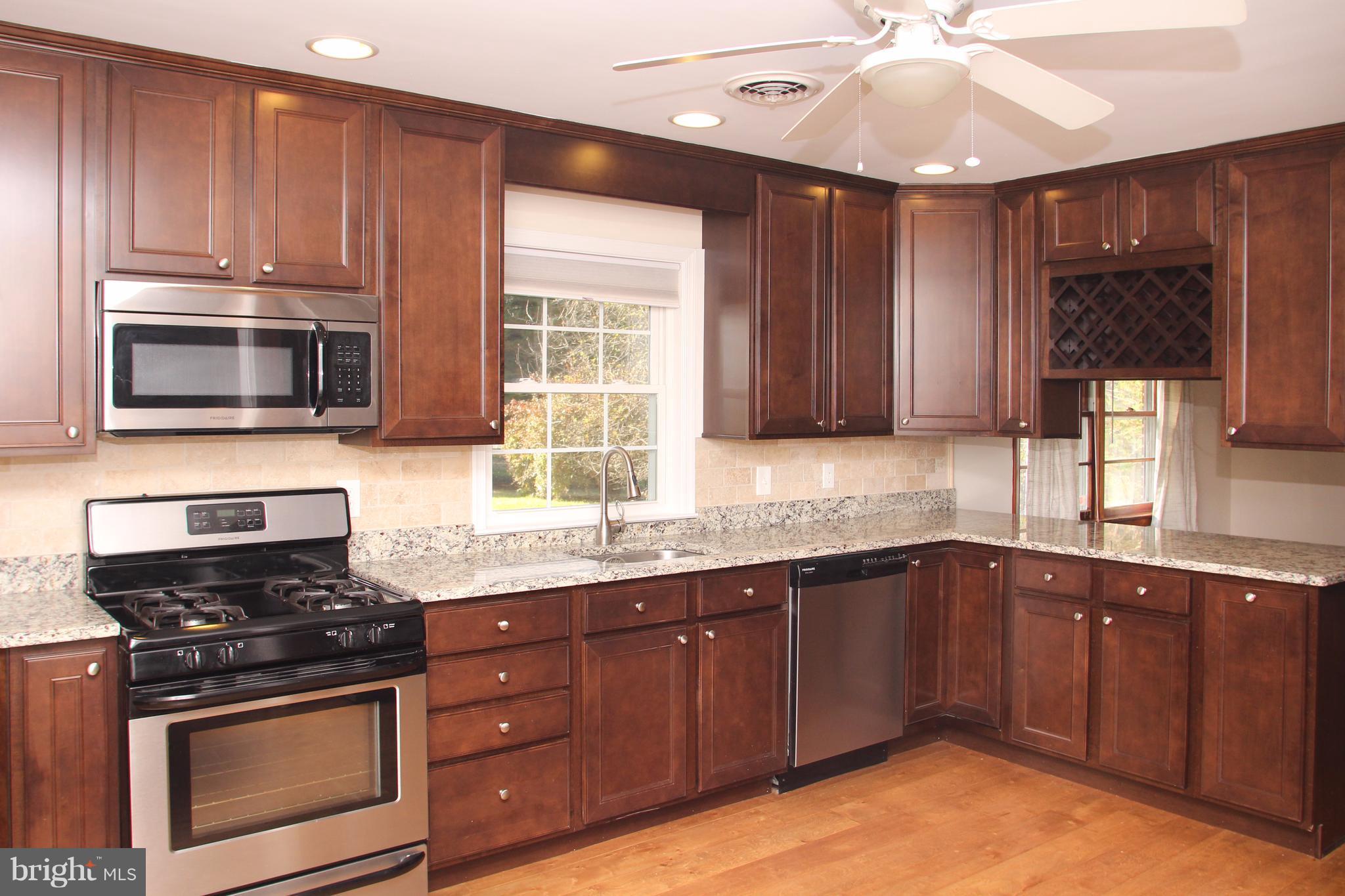 610 Mountain Road Fallston, MD 21047 - Photo 11 of 29 a kitchen with stainless steel appliances granite countertop wooden cabinets stove top oven and microwave