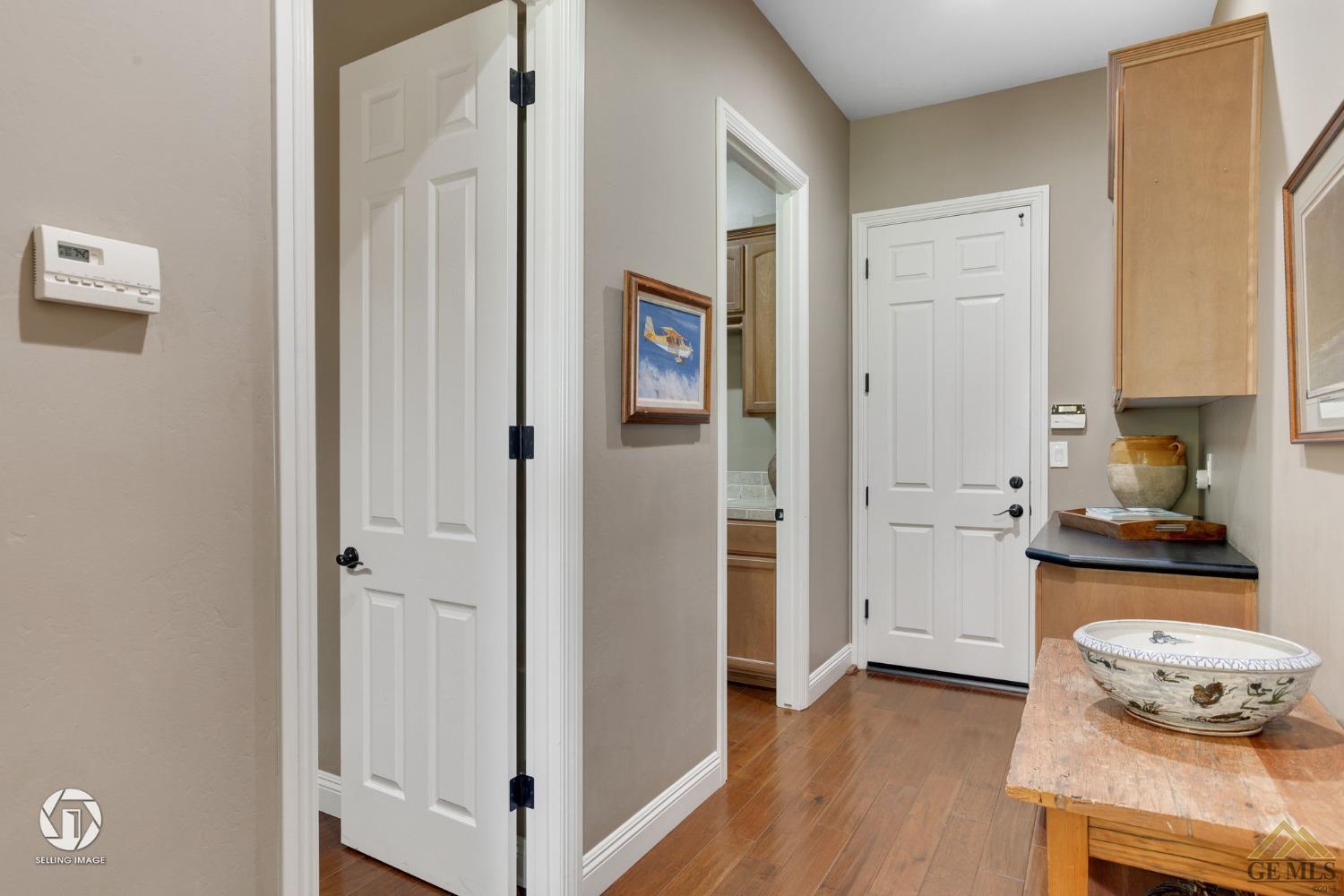 Undisclosed Address Bakersfield, CA 93311 - Photo 30 of 58 a view of a hallway with cabinet and wooden floor