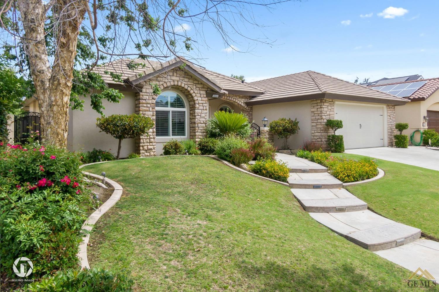 Undisclosed Address Bakersfield, CA 93311 - Photo 5 of 58 a front view of a house with a yard and potted plants