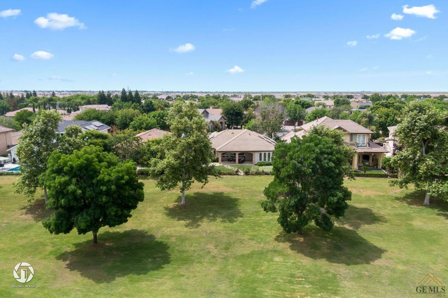 Undisclosed Address Bakersfield, CA 93311 - Photo 53 of 58 a view of a garden with a bench under an umbrella
