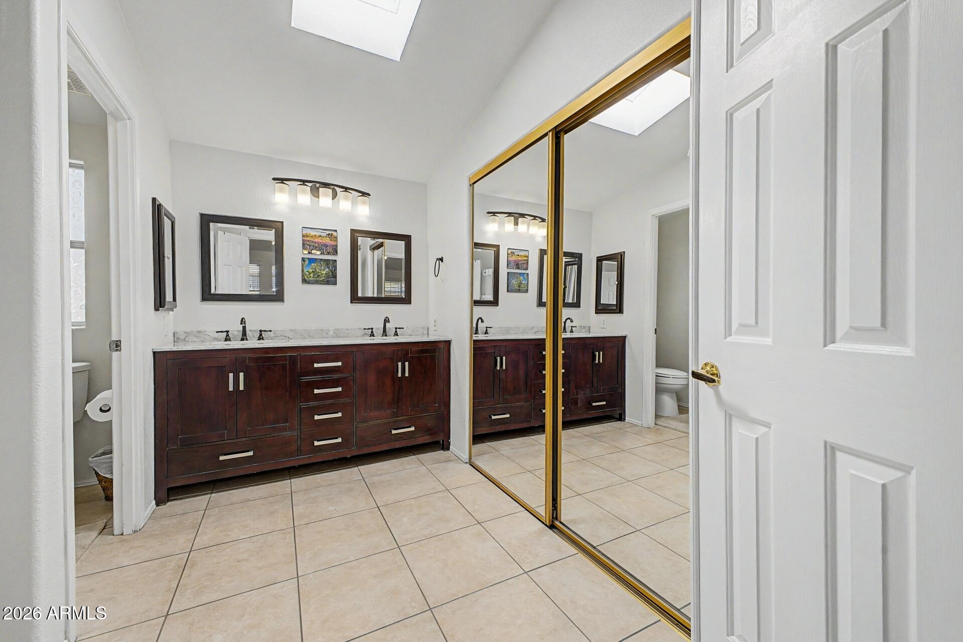 2550 South Ellsworth Road, Unit 46 Mesa, AZ 85209 - Photo 18 of 46 a spacious bathroom with a granite countertop sink and a mirror