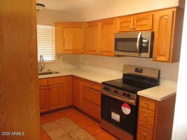 a kitchen with stainless steel appliances granite countertop a sink stove and microwave