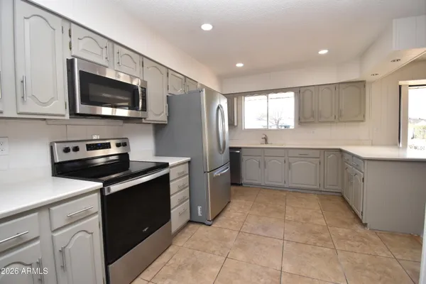 a kitchen with stainless steel appliances granite countertop a sink dishwasher a stove and a microwave oven with cabinets