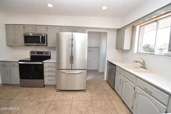 a kitchen with stainless steel appliances a refrigerator sink and microwave