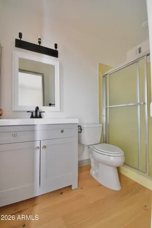 a bathroom with a toilet sink vanity and mirror
