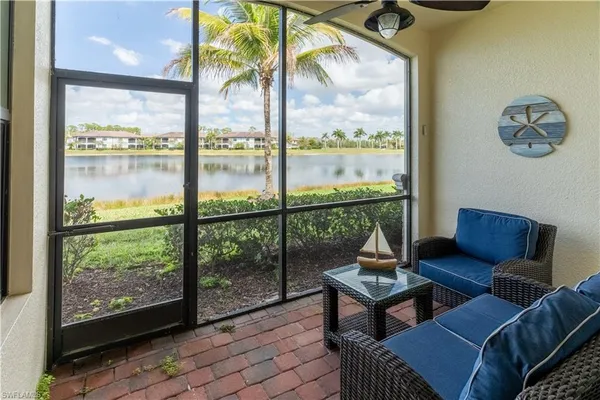 a living room with a couch a table and a floor to ceiling window