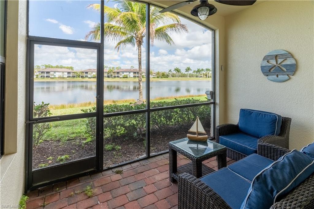 9517 Avellino Way, Unit 2214 Naples, FL 34113 - Photo 1 of 44 a living room with a couch a table and a floor to ceiling window