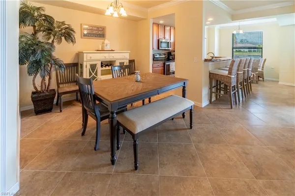 a living room with furniture a dining table and a potted plant