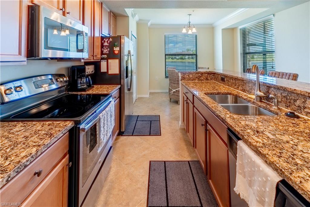 9517 Avellino Way, Unit 2214 Naples, FL 34113 - Photo 14 of 44 a kitchen with granite countertop a stove a sink and a refrigerator