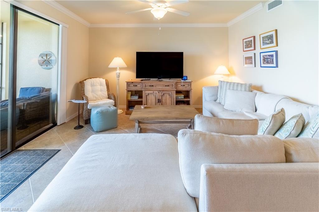 9517 Avellino Way, Unit 2214 Naples, FL 34113 - Photo 17 of 44 a living room with furniture and a flat screen tv