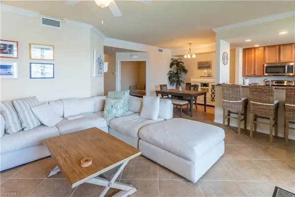 a living room with couches a kitchen view and a dining table with kitchen view