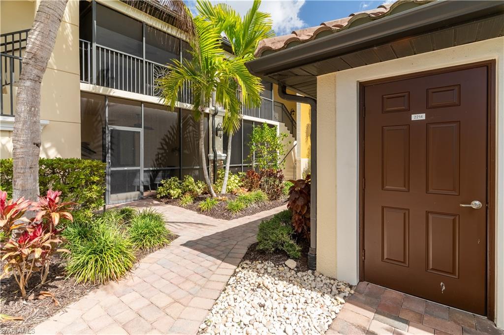 9517 Avellino Way, Unit 2214 Naples, FL 34113 - Photo 2 of 44 a view of a house with a small yard and potted plants