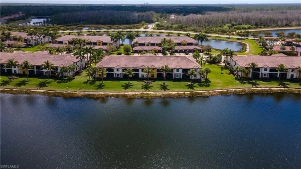 an aerial view of residential houses with outdoor space and lake view