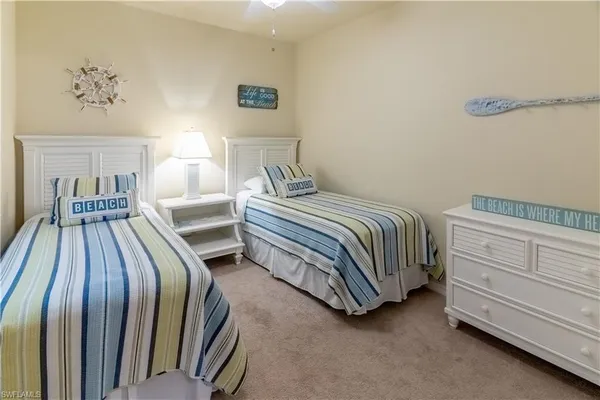 a bedroom with two beds and painting on the wall