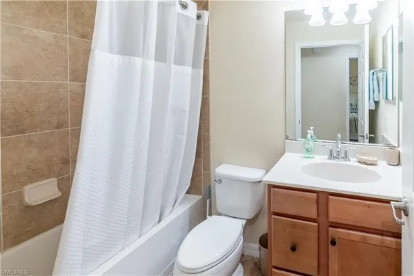 a bathroom with a sink a toilet a mirror and shower curtain