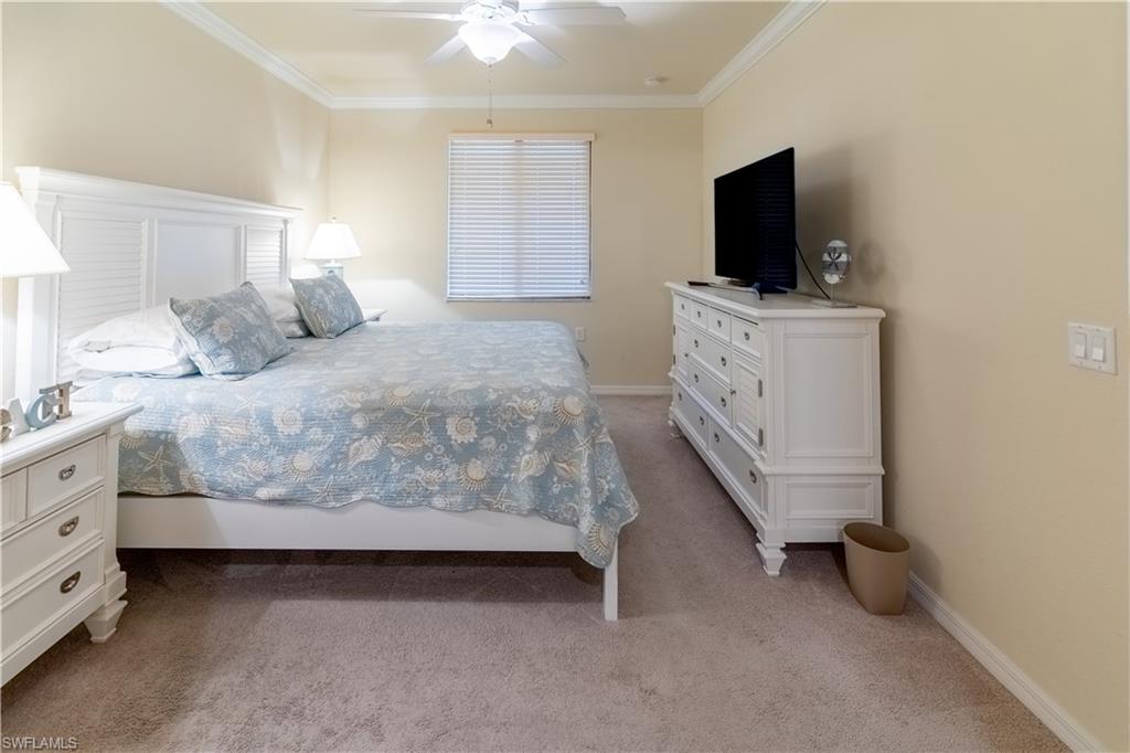 9517 Avellino Way, Unit 2214 Naples, FL 34113 - Photo 9 of 44 a bedroom with a bed and a flat screen tv
