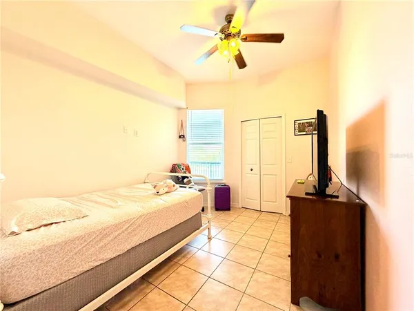 a bedroom with a bed and a chandelier fan